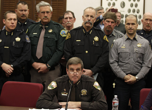 Weld County Sheriff John Cooke, center, backed by a group of fellow sheriffs, testifies against proposed gun control legislation in the Colorado Legislature, at the State Capitol, in Denver, Monday March 4, 2013. State Senate committees began work Monday on a package of gun-control measures that already have cleared the House which include limits on ammunition magazine sizes and expanded background checks to include private sales and online purchases. (AP Photo/Brennan Linsley)